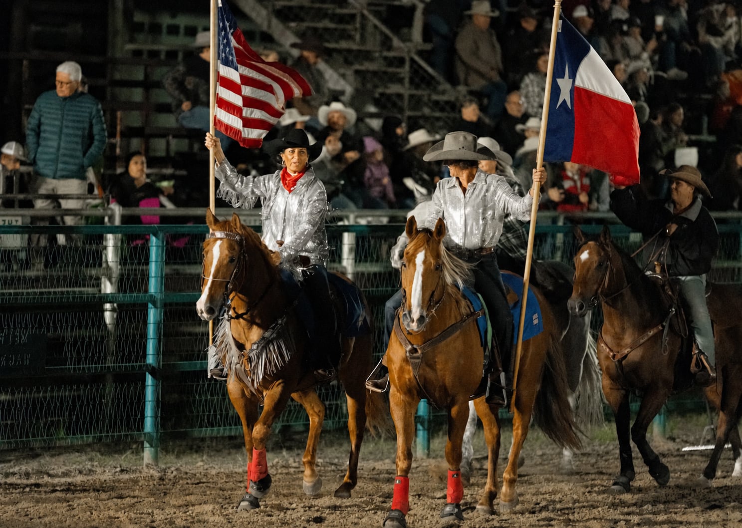 Mounted flag riders carry the United States and Texas flags at A Thomson Rodeo